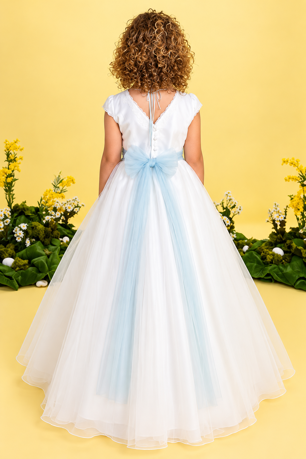 Espalda de vestido de comunión Lilus con gran lazada de tul azul celeste.