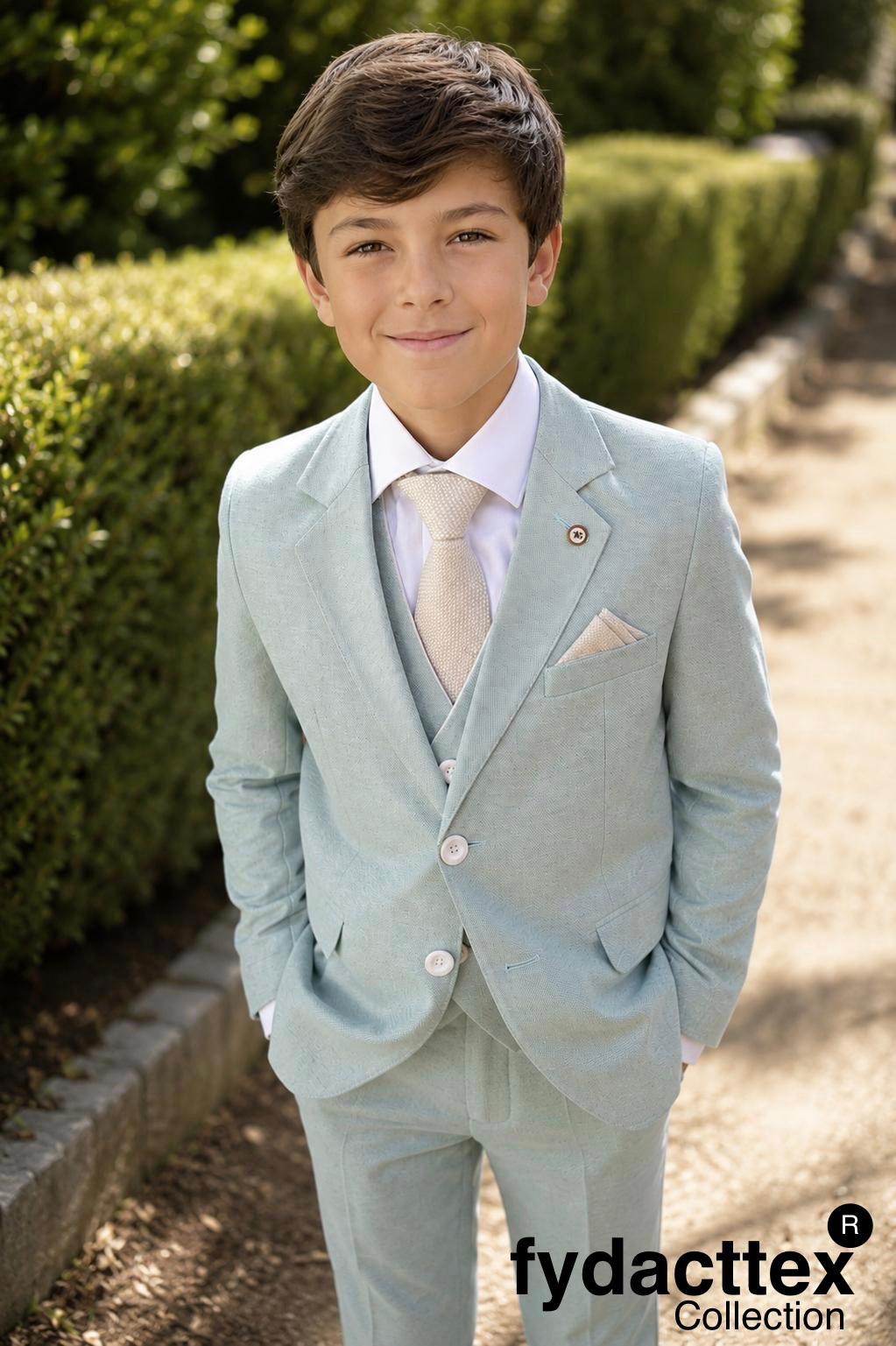 Niño con traje y chaleco de comunión verde agua, corbata y pañuelo beige.