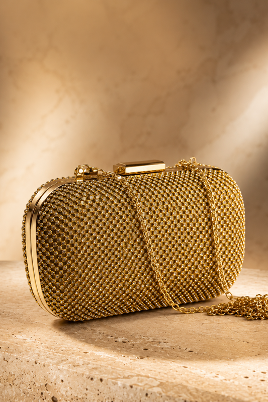 Bolso de fiesta dorado con pedrería brillante y cadena metálica para invitadas de boda, ceremonias y eventos elegantes.