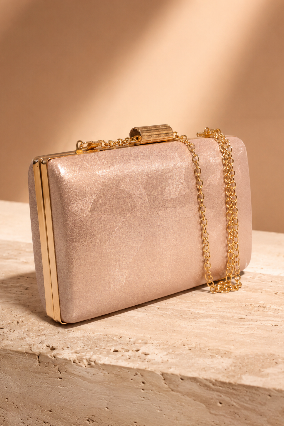 Bolso de fiesta oro rosa para invitada de boda con cadena dorada, diseño tipo clutch elegante y acabado brillante.